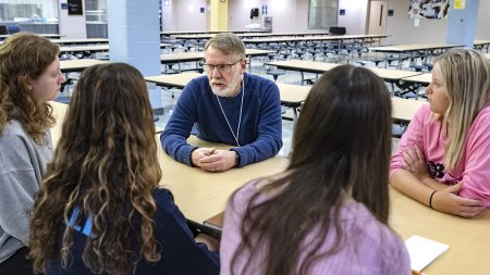 A man talks with a group of students.