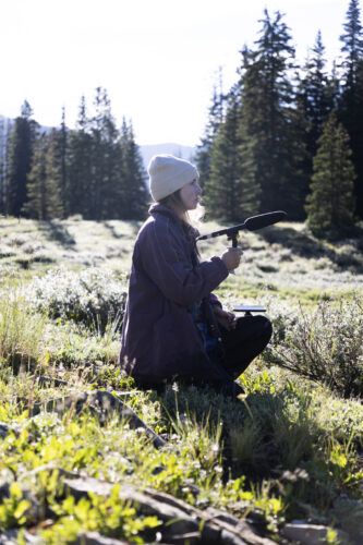 A student using a microphone in the mountains.