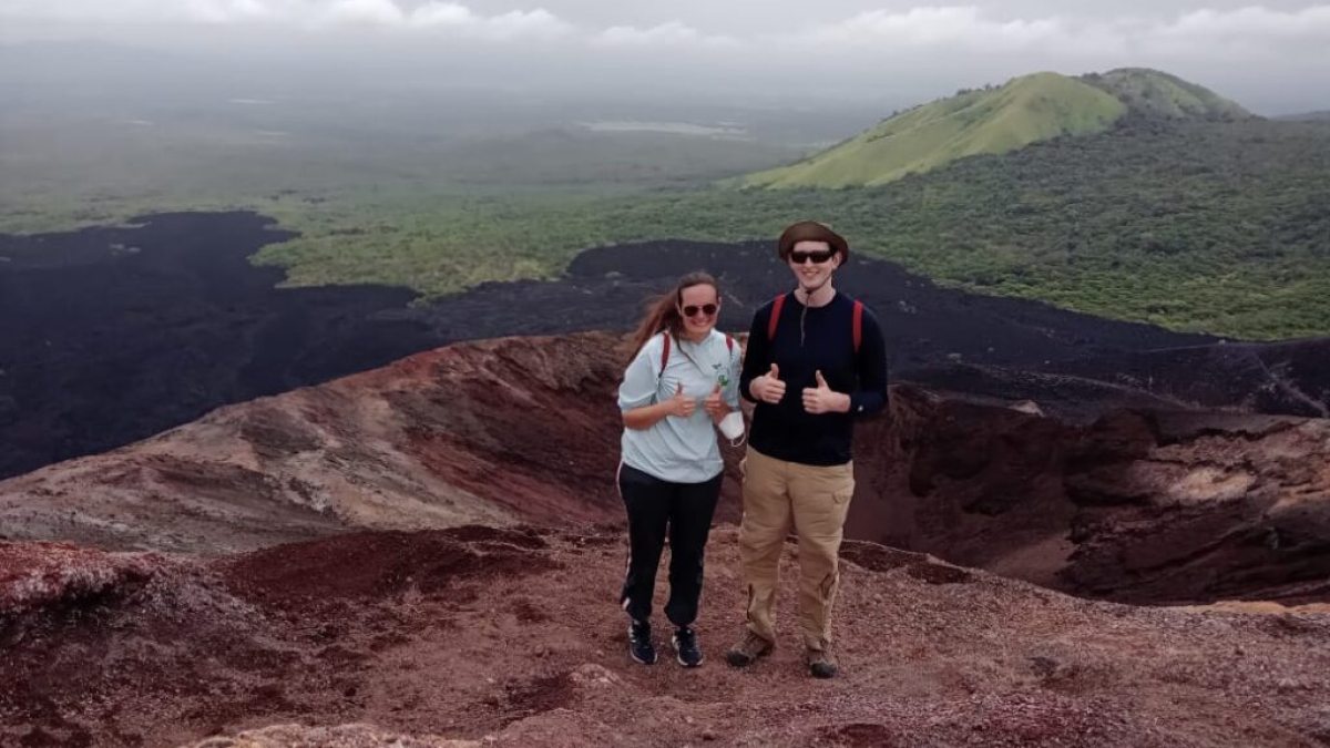 Two people standing on a volcano.