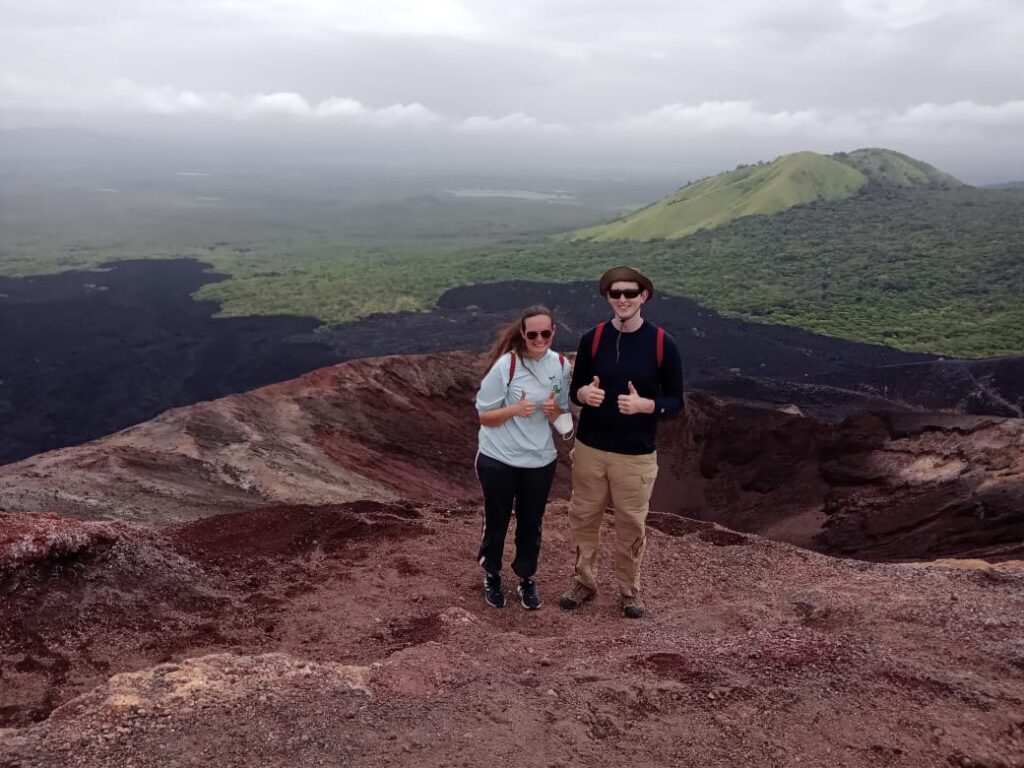 Two people standing on a volcano.