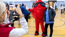 A person takes a photo with a blood drop mascot.