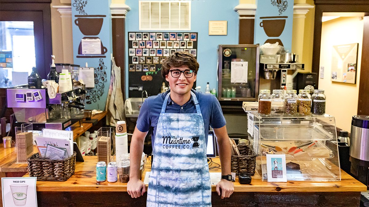 Carson Moore, the CEO of Meantime Coffee Company, in front of the coffee bar.