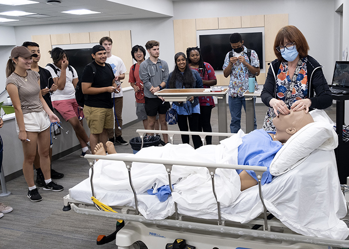 Students around a mock patient. 