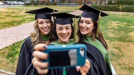 Graduates pose for a selfie together.