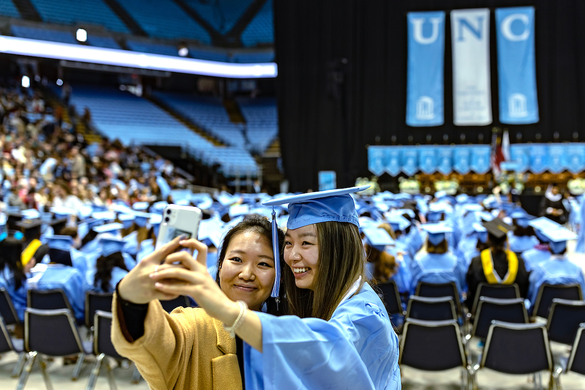 A graduate poses for a selfie.