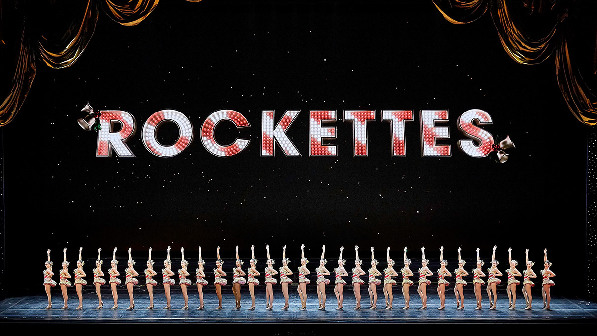 A line of Rockette dancers on stage