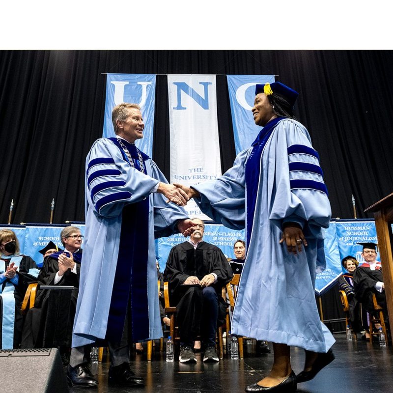 The chancellor shakes hands with a graduate.