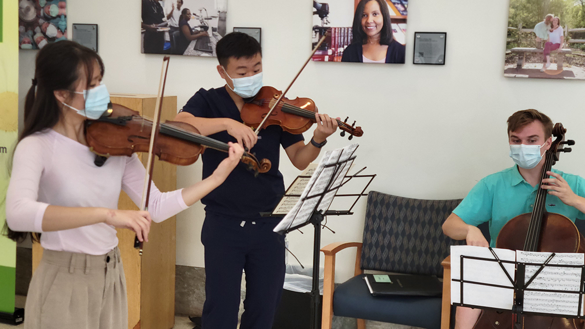 Students in masks with violins and music stands. 