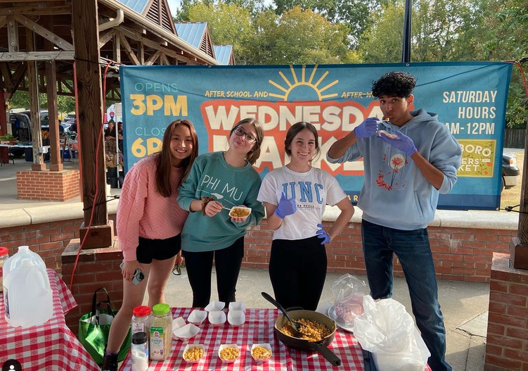 Students pose for a photo at a farmer's market.