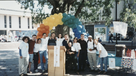 students pose for a photo in the pit with balloons behind them.