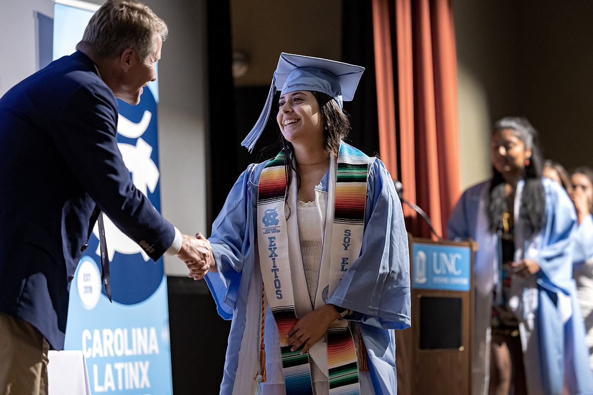A UNC graduate shakes hands at Exitos. 