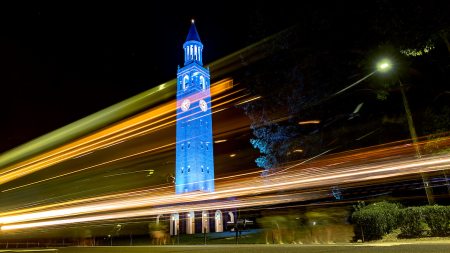 The bell tower lit up in Carolina Blue at night.