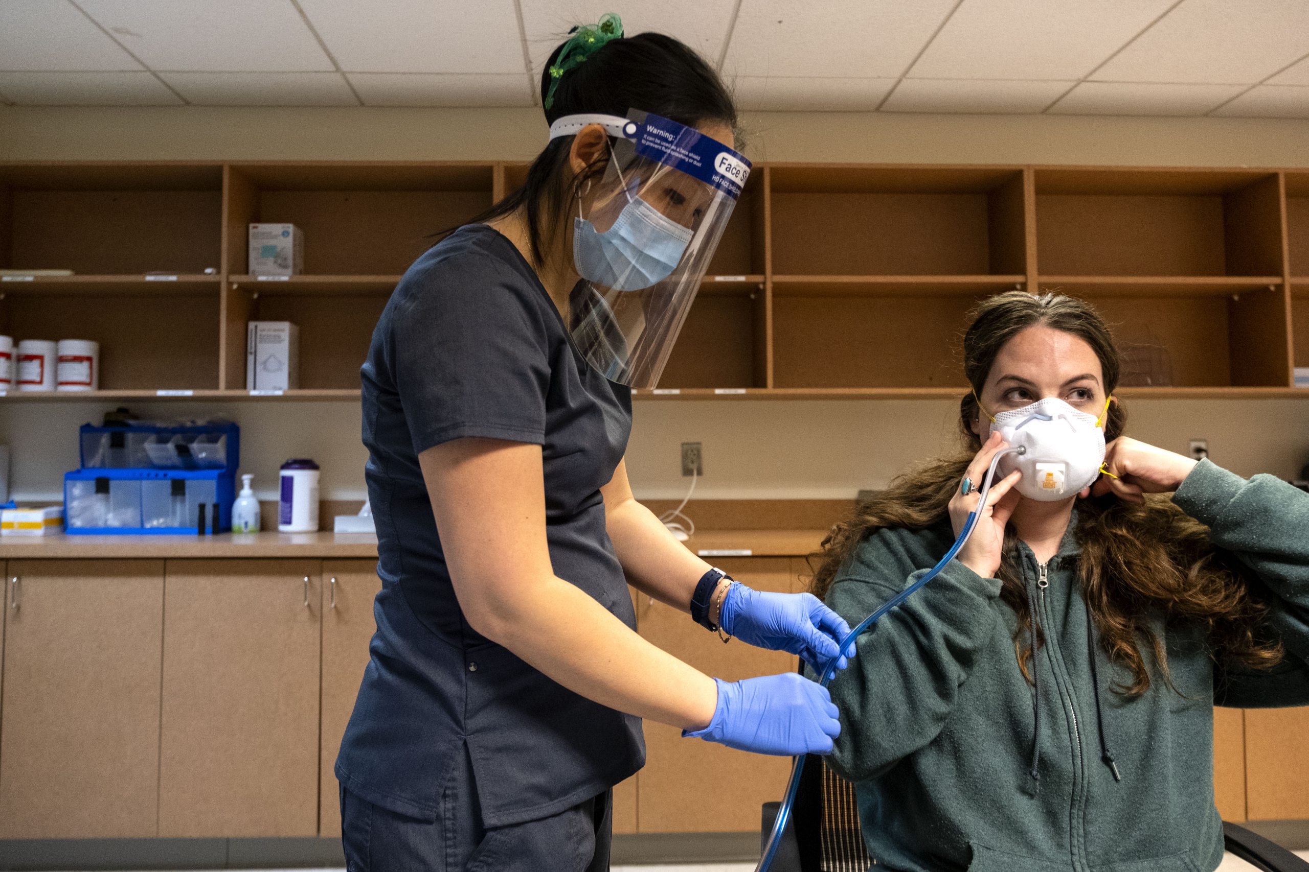 In full PPE, occupational health nurse Jeanne Brueggemann performs a routine mask fit test on Chelsi Holle. This was a common test at the clinic before mask-wearing became the new normal. (Jon Gardiner/UNC-Chapel Hill)