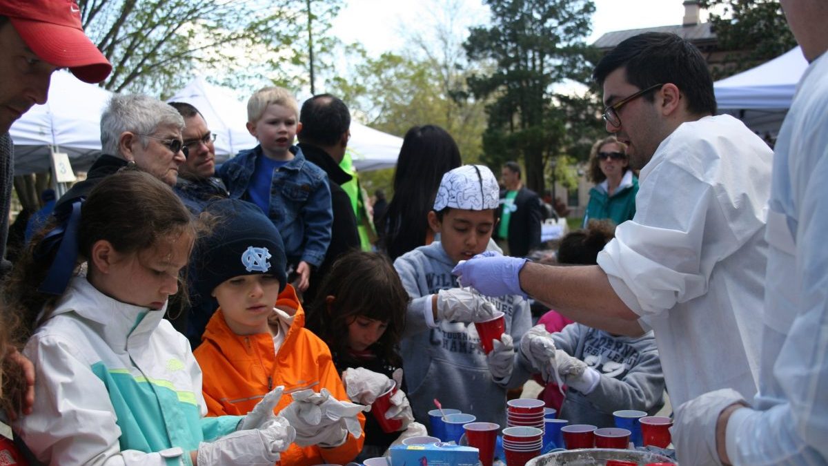 Children holding plastic cups and participating in a science activity.