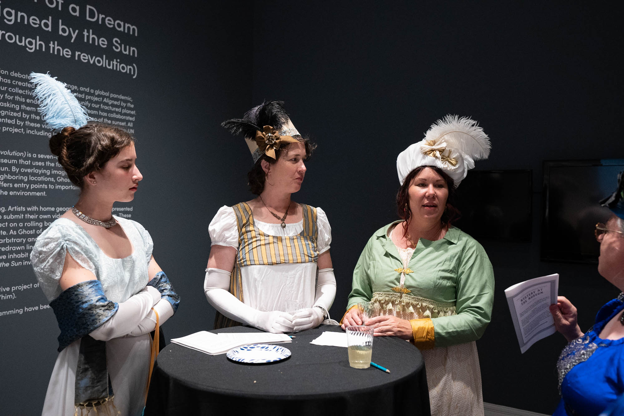 Attendees wearing Regency period costumes take a break during the mystery event.