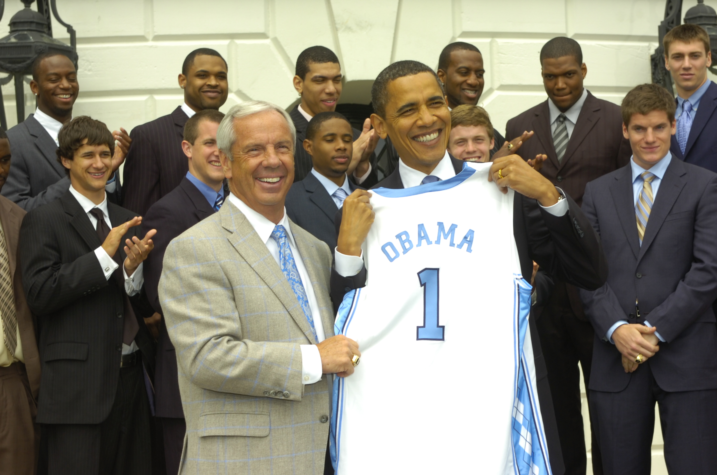 Roy Williams presenting President Barack Obama a Carolina jersey with the number 1 and the name Obama.