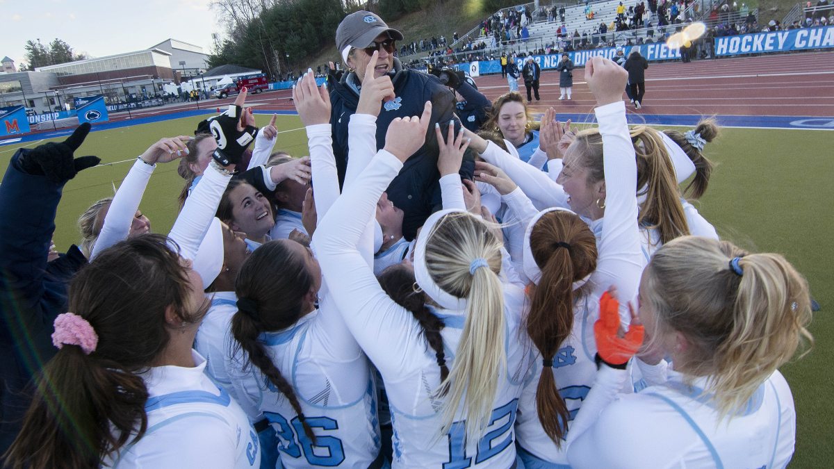 The UNC field hockey team and then-coach Karen Shelton huddled and celebrating a national championship.
