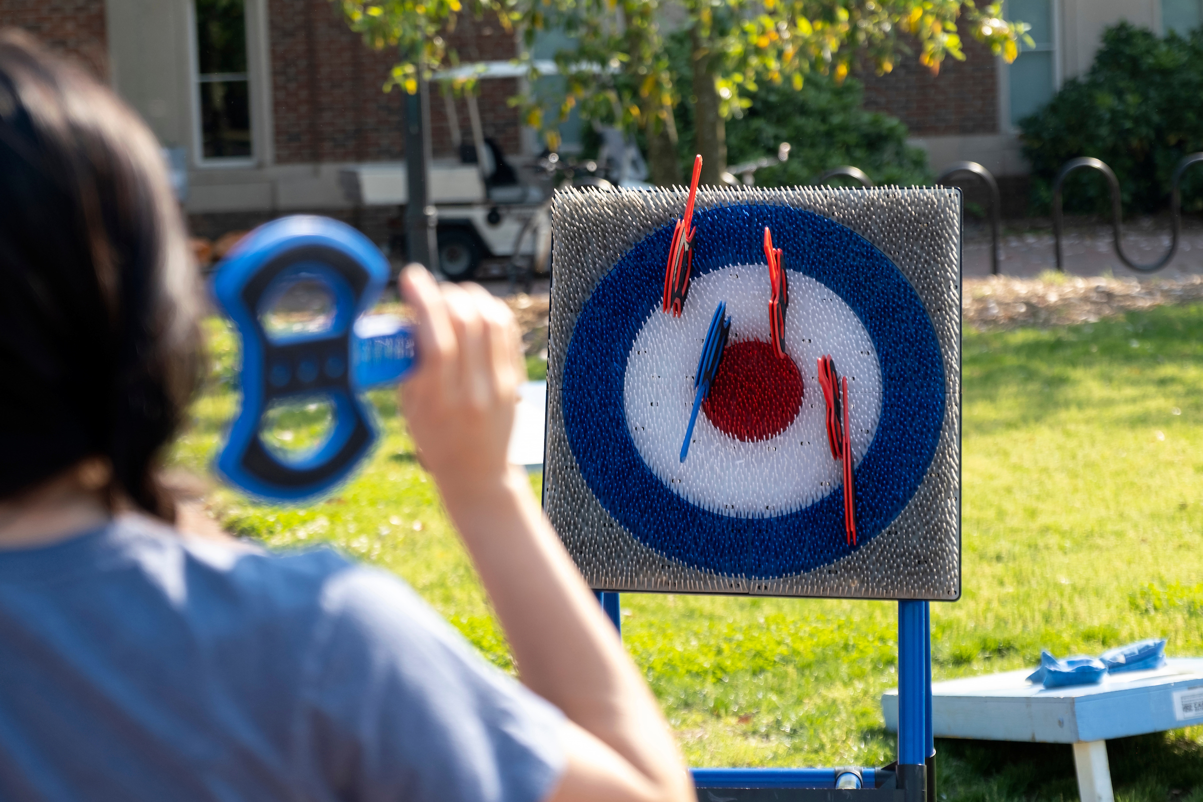 A student prepares to throw a soft ax at a velcro bullseye.