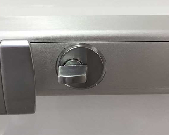 A closeup image of a push bar door lock.