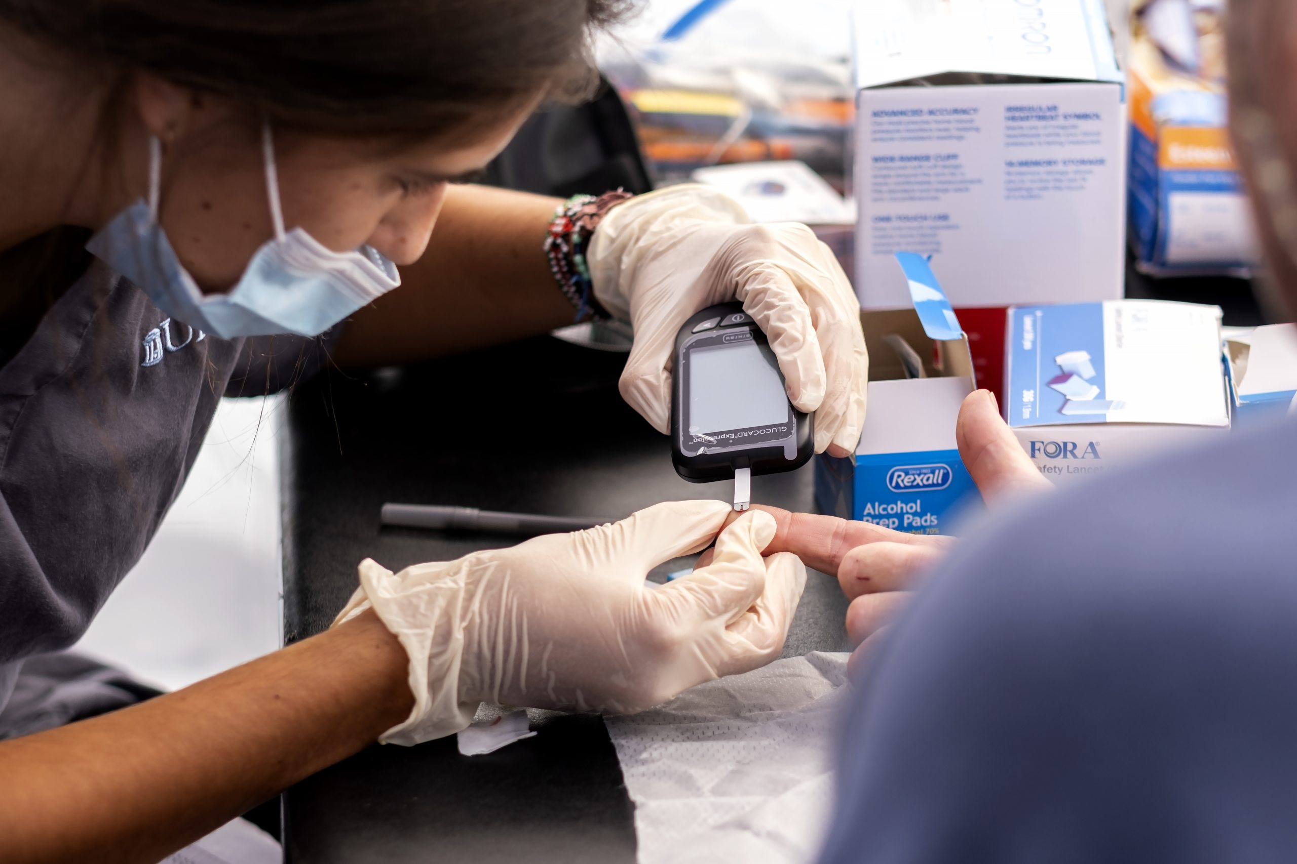 A nursing student check a person's glucose level.