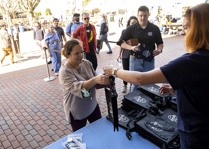 Employees line up to get a free lunch bag at Carolina's Employee Wellness Day event.