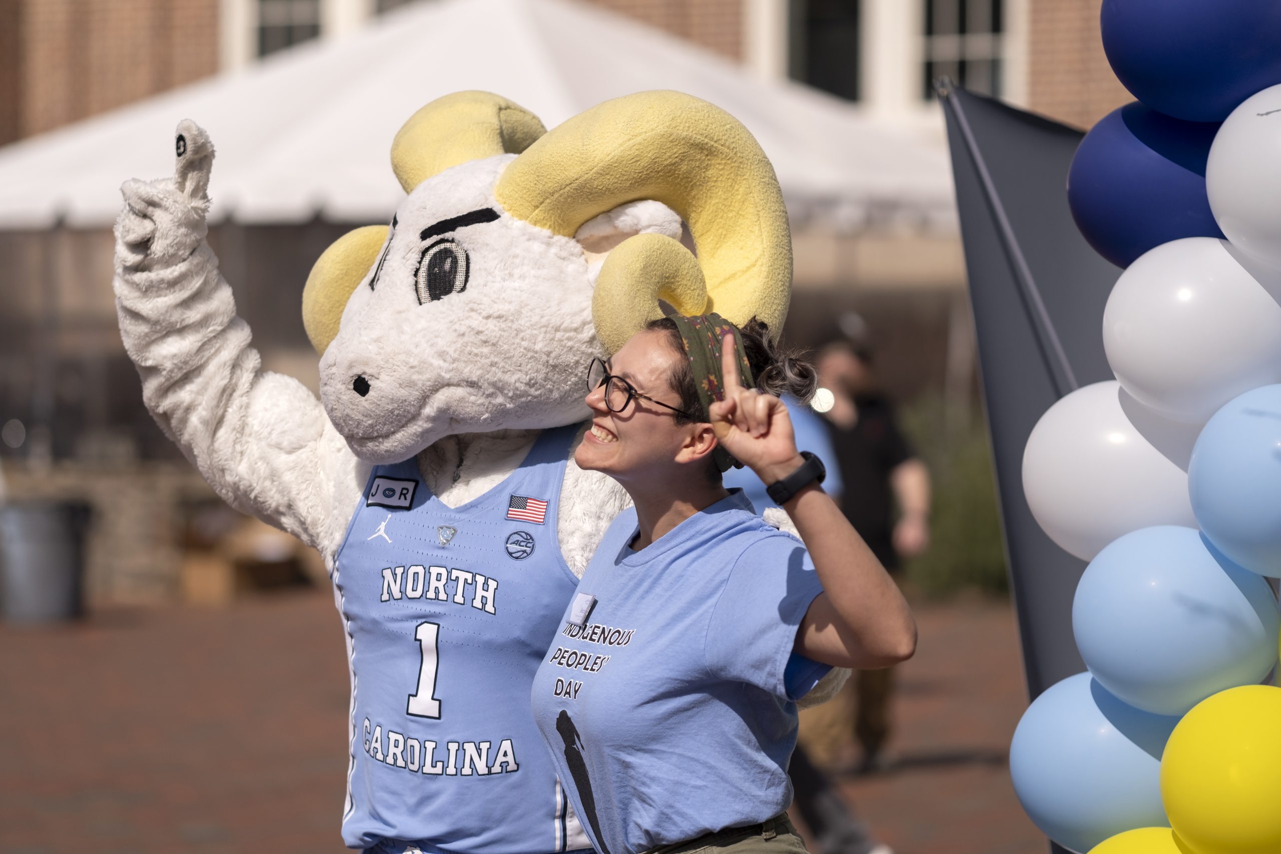 Mascot Rameses and a U.N.C. employee raise their fingers to signify number one.