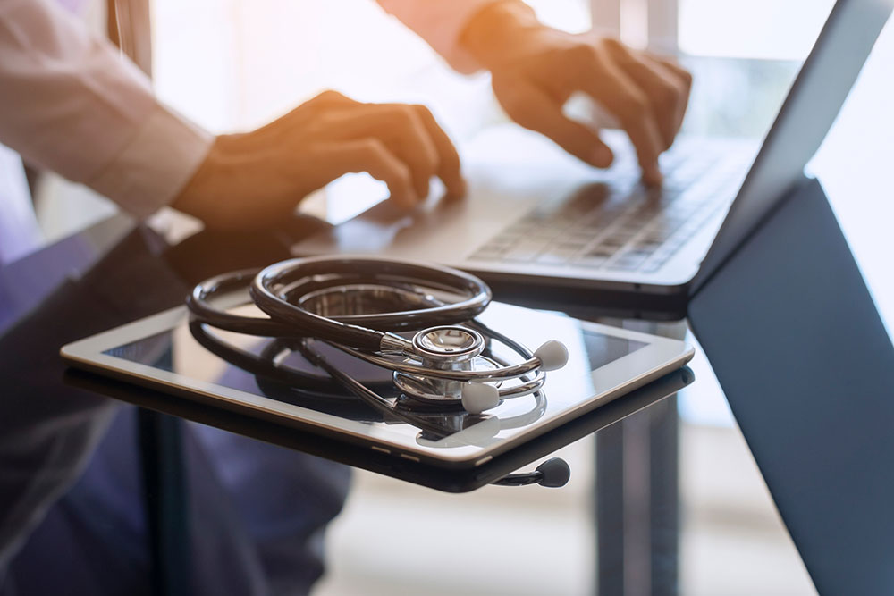 A tablet and a laptop with a stethoscope