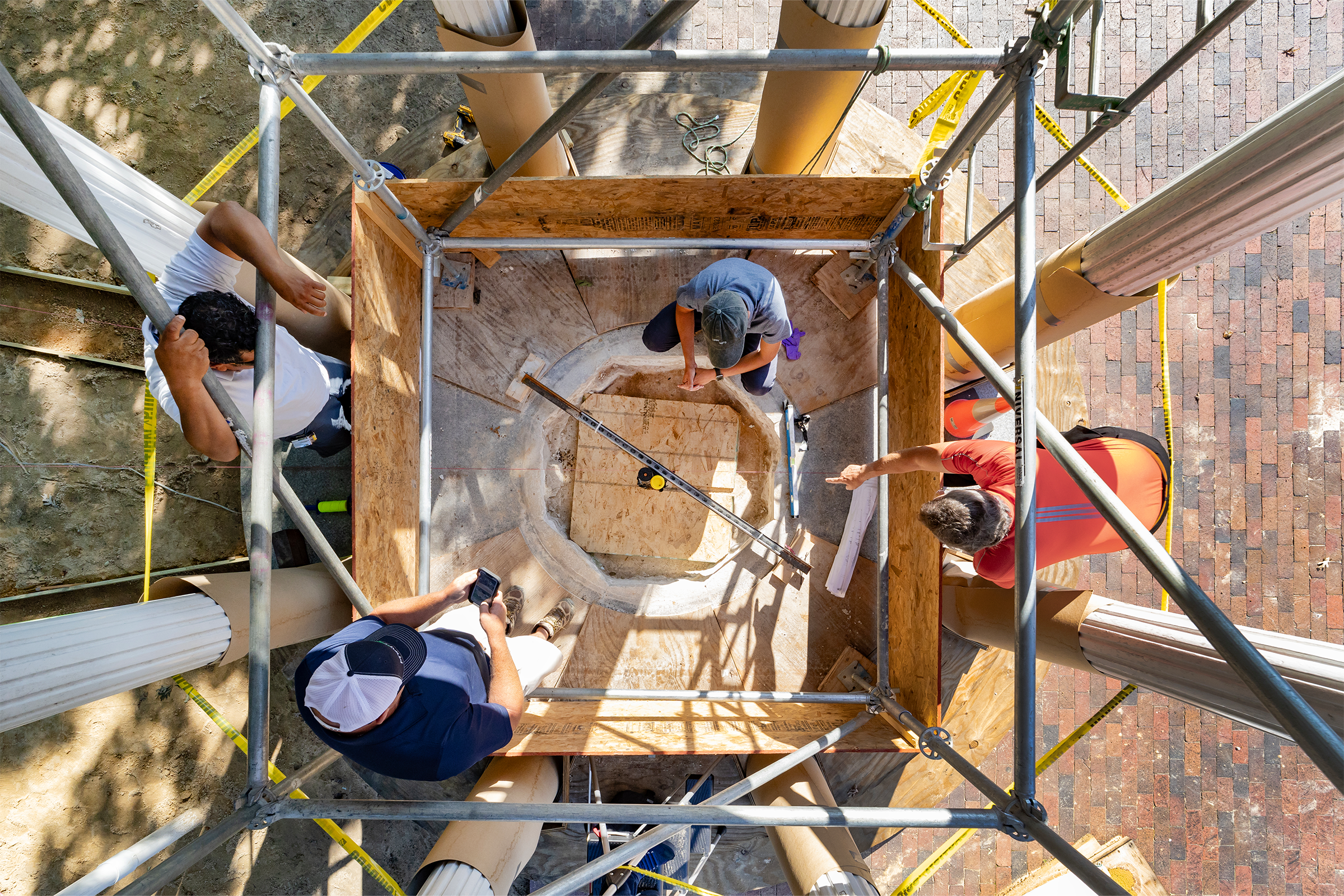 An overhead view of workers having a meeting in the interior of the Old Well structure.