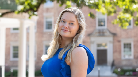 A student, Heather Norland, posing for a photo near the Old Well on the campus of UNC-Chapel Hill.