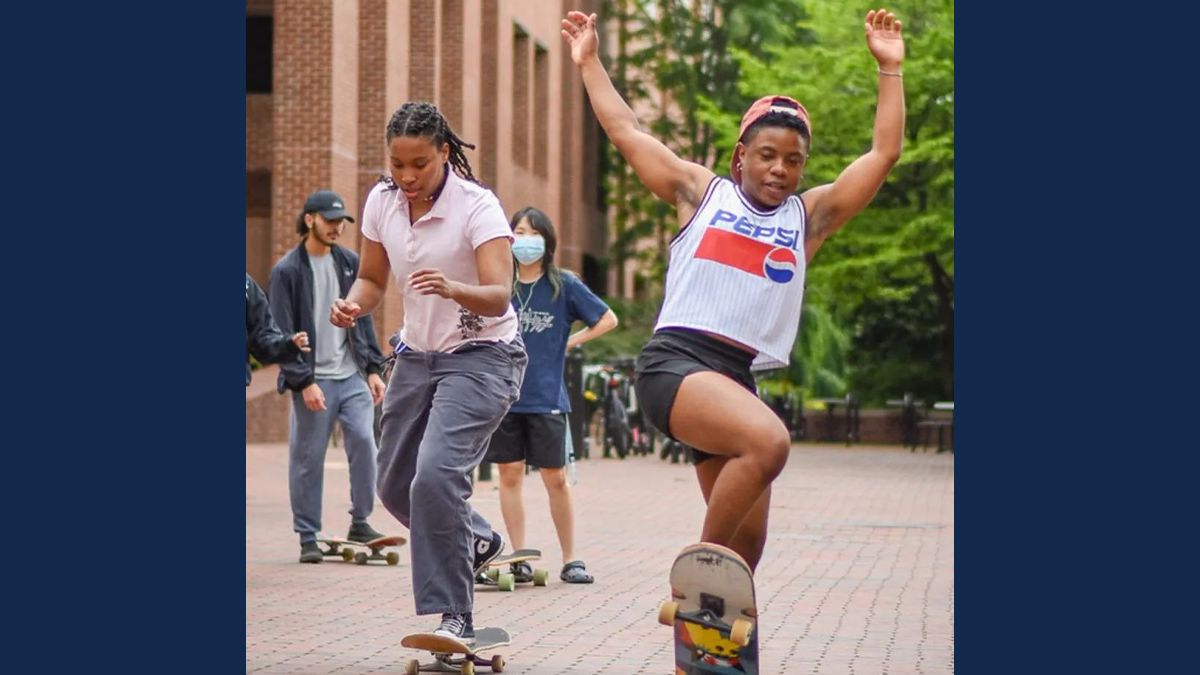 Louise Hoff and other students skateboarding on the campus of UNC-Chapel Hill.