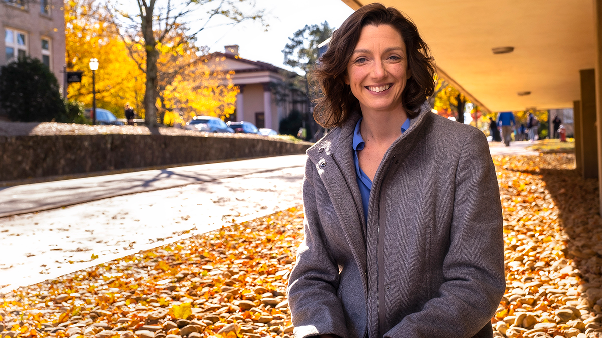 Sara Algoe wearing a grey jacket, in front of Sitterson Hall.