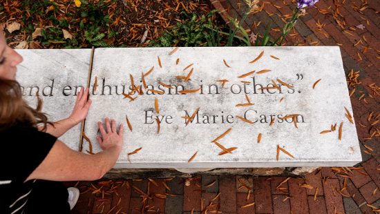 A UNC-Chapel Hill student, Emily Smither, clears fallen leaves from the Eve Carson Memorial on campus. Displayed on the memorial is a portion of famous quote from Carson reading 