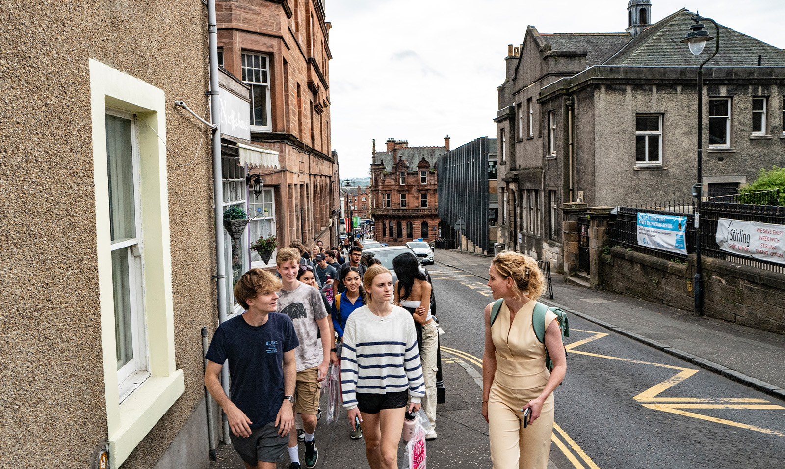 Students walking and talking on sidewalk in Stirlig, Scotland.