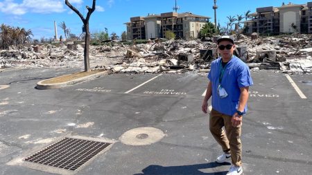 David Kim standing in front of devastation in Maui.