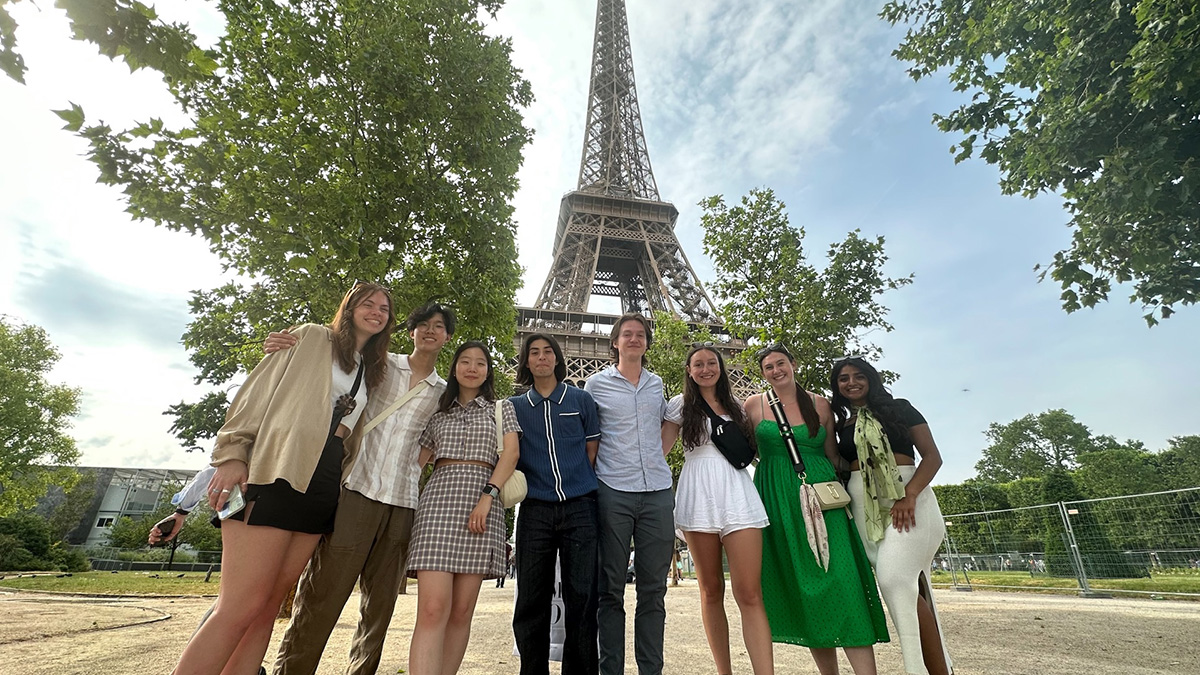 Several students pose in front of the Eiffel Tower.