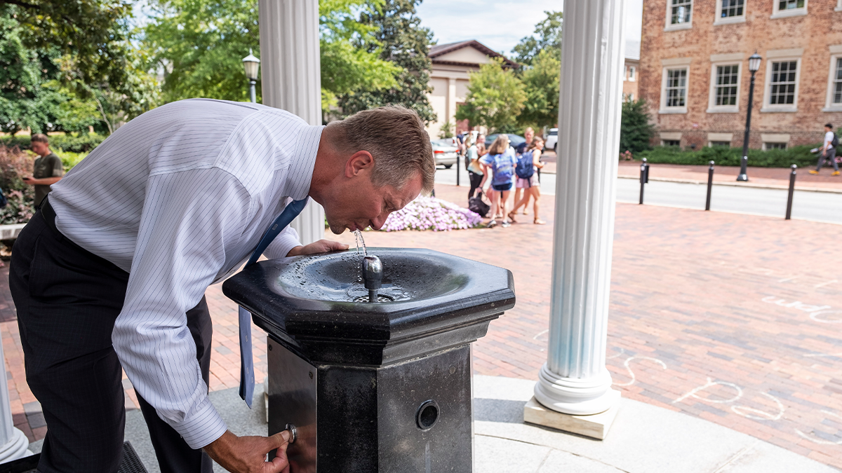 Chancellor Kevin M. Guskiewicz sipping from the Old Well on the campus of UNC-Chapel Hill on the first day of classes.