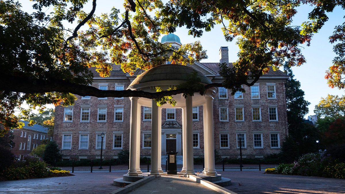 The Old Well on the campus of UNC-Chapel Hill on a sunny morning with South Building seen in the background.