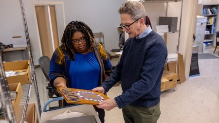 A man and a woman looking over submissions to the student organizations archive at Wilson Library.