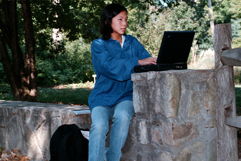 A student using her 1990s-era laptop on the campus of UNC-Chapel Hill.