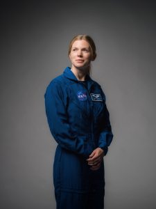 Portrait of Zena Cardman looking dramatically off-camera with blue flight suit.