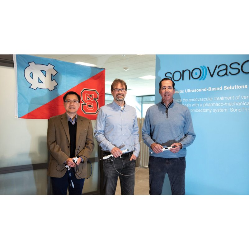 Xiaoning Jiang, Paul Dayton and Dan Estay in front of a UNC/NC State flag