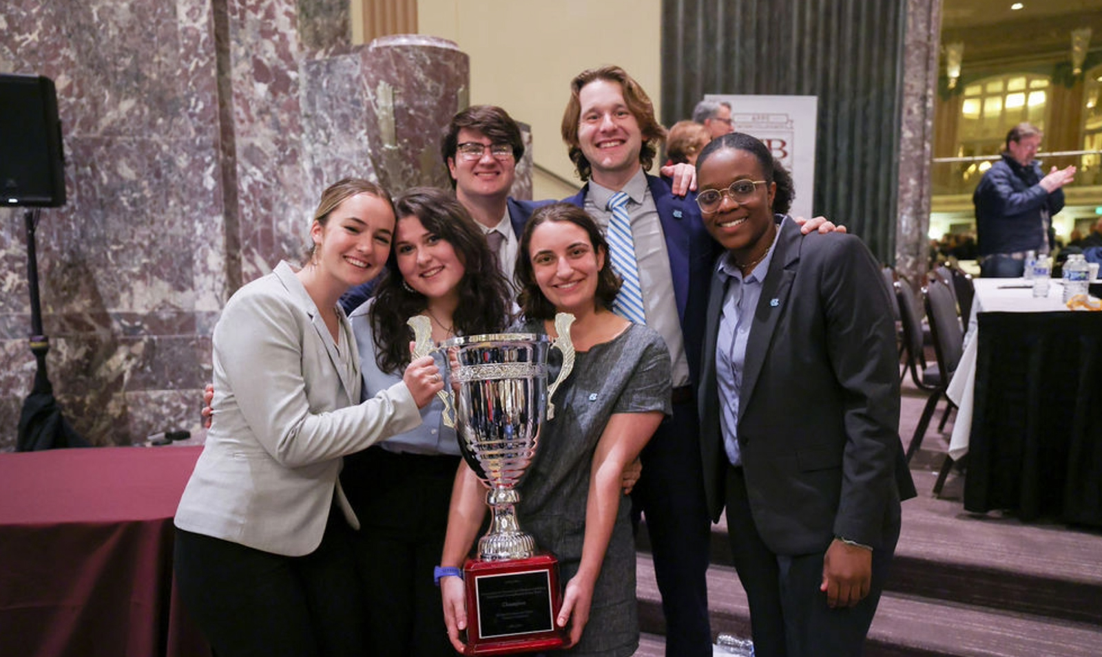 Six members of the UNC Ethics Bowl team posing with award in hands.