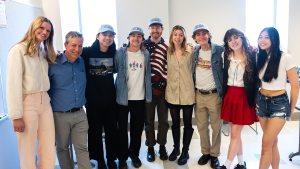 Group photo in a classroom of associate professor Marc Cohen and six students from his English 105 class with the two band members of Hotel Fiction, Jess Thompson and Jade Long.